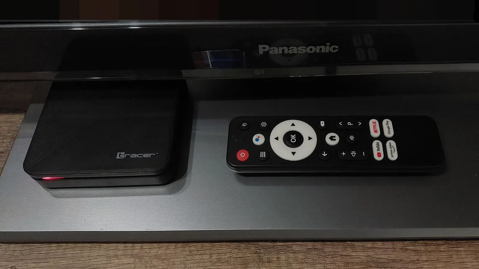 File photo of an Android TV-based Tracer set-top box beside its remote under a television, the kind of low-cost connected device in Anthropic's test