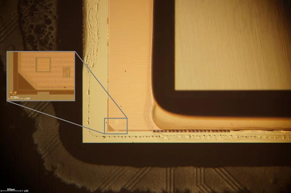 Contextual file photo: microscope close-up of a silicon interposer corner on an AMD graphics package, not a GlobalFoundries or TSMC part from this deal