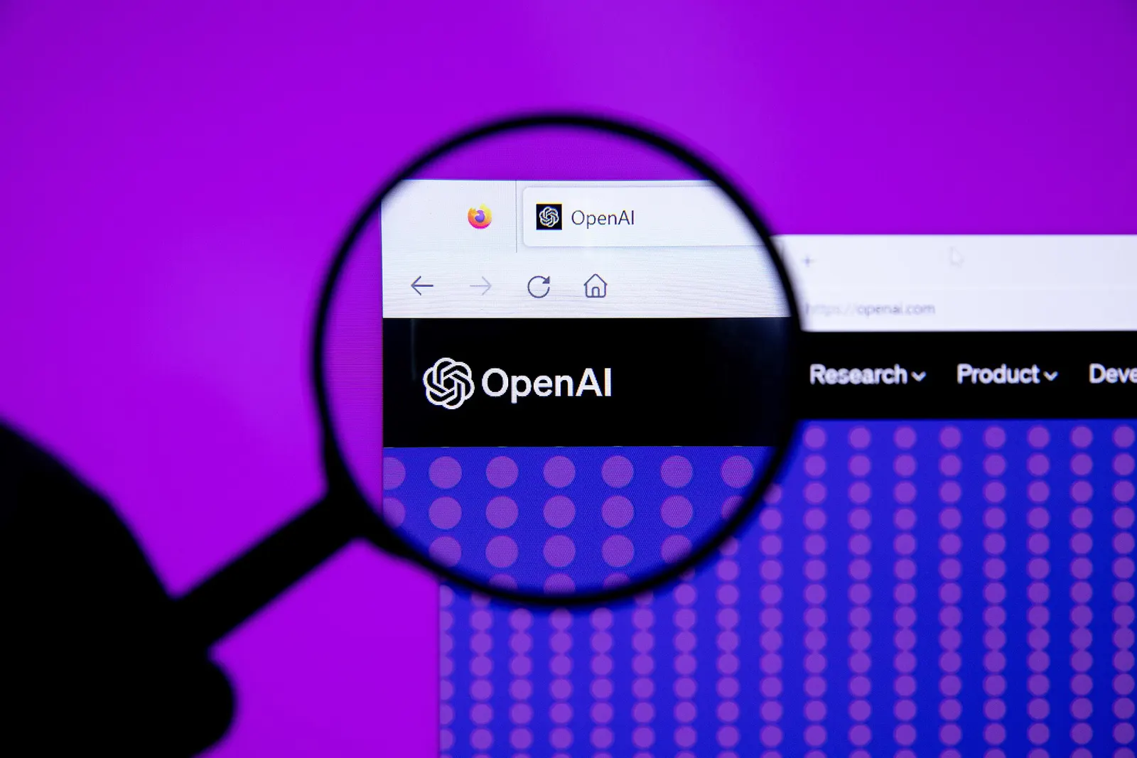 Contextual illustration: the OpenAI website logo seen through a magnifying glass on a computer screen.