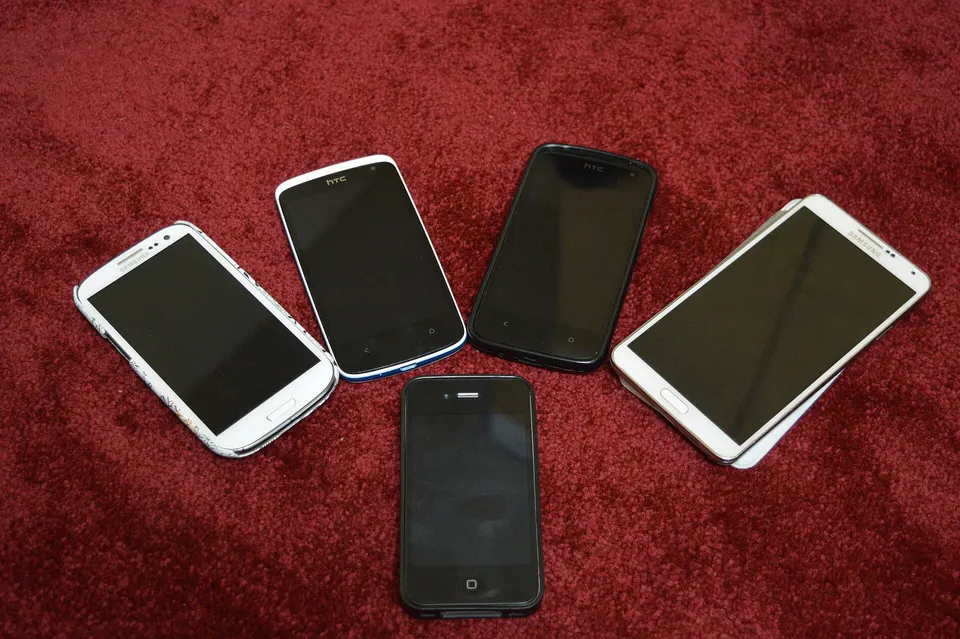 Several smartphones arranged on a carpet; contextual file photo.